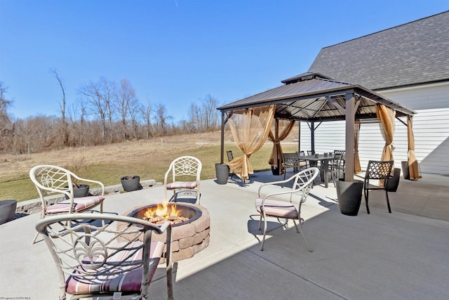 view of patio featuring a gazebo, outdoor dining area, and a fire pit