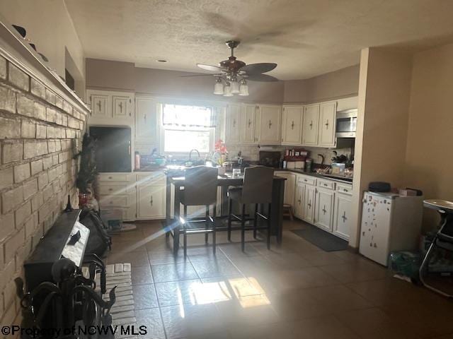 15401/2 Country Club Rd, Fairmont, WV 26554 - kitchen with ceiling fan, stainless steel microwave, white cabinets, tile patterned flooring, and dark countertops