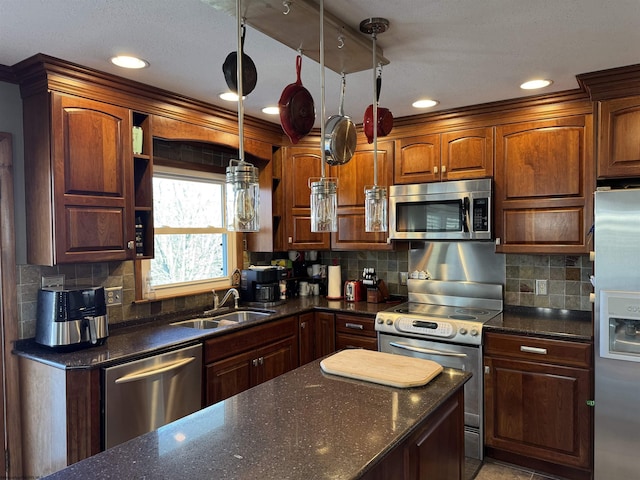 kitchen featuring a sink, dark stone countertops, tasteful backsplash, and stainless steel appliances