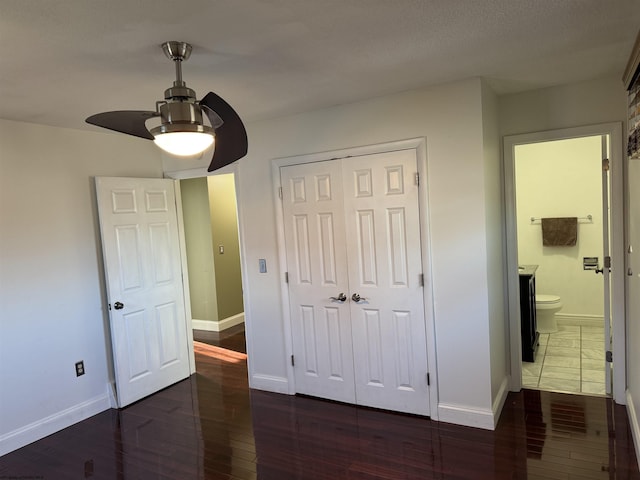 bedroom with hardwood / wood-style flooring, baseboards, and a closet