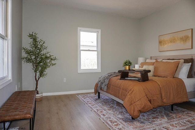 bedroom featuring baseboards and wood finished floors