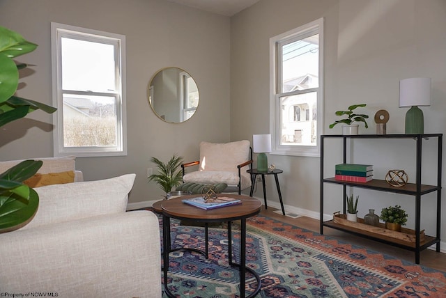 sitting room featuring plenty of natural light, baseboards, and wood finished floors