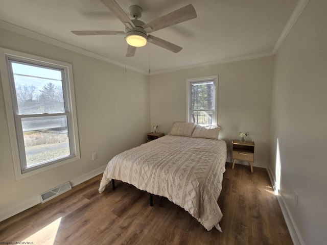 bedroom with dark wood-type flooring, baseboards, visible vents, and ornamental molding