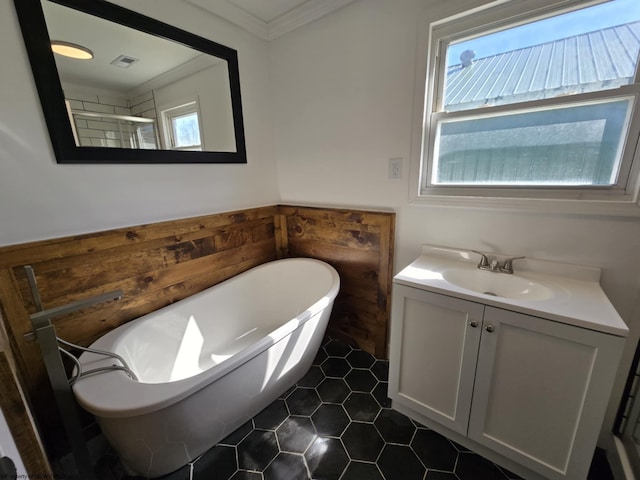 full bathroom with visible vents, crown molding, a freestanding tub, a shower with shower door, and vanity