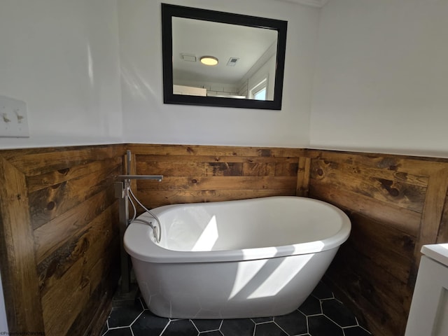 full bathroom featuring a freestanding tub, wooden walls, and a wainscoted wall