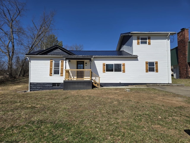 back of house with metal roof, a lawn, and a porch