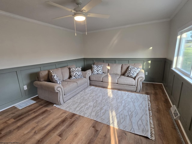 living area featuring wood finished floors, visible vents, and wainscoting