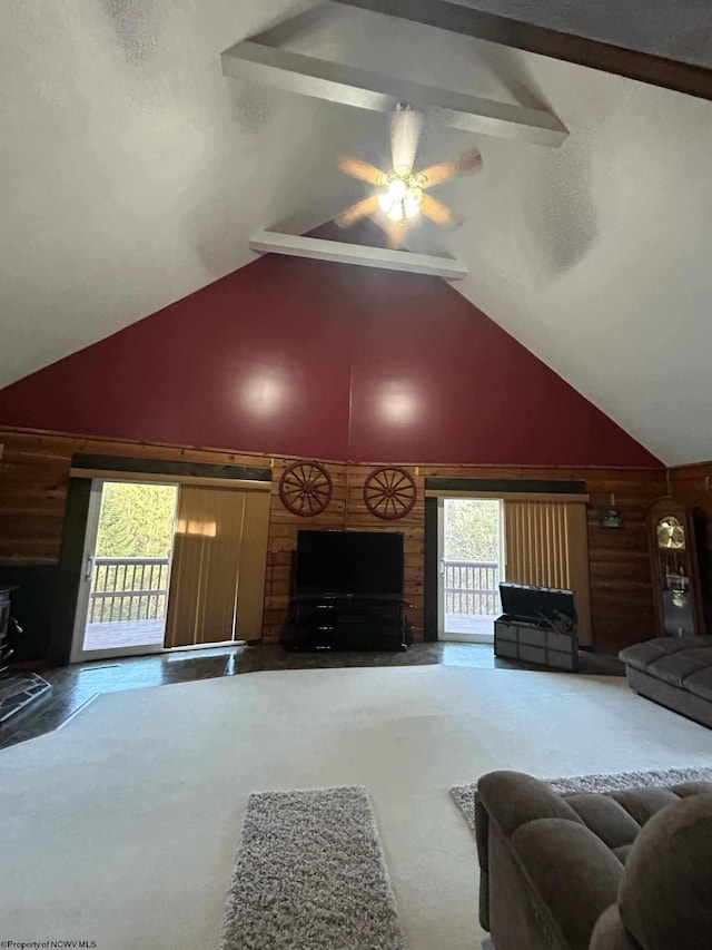 carpeted living area with beamed ceiling and high vaulted ceiling