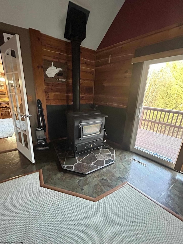 room details featuring a wood stove, visible vents, and wood walls