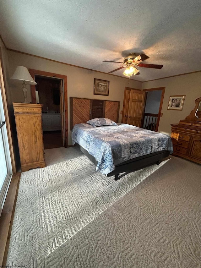 carpeted bedroom with ceiling fan, crown molding, and a textured ceiling