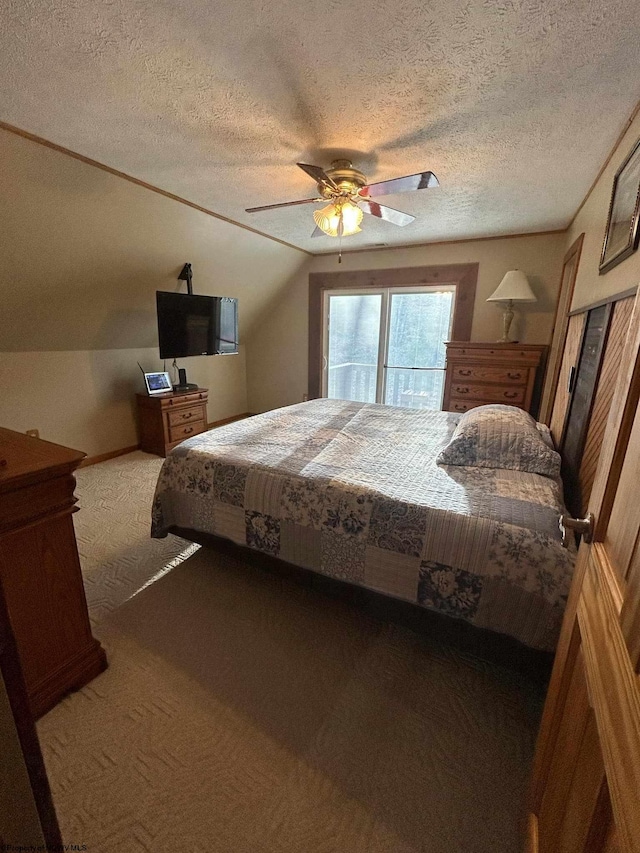 bedroom with ceiling fan, lofted ceiling, carpet flooring, and a textured ceiling