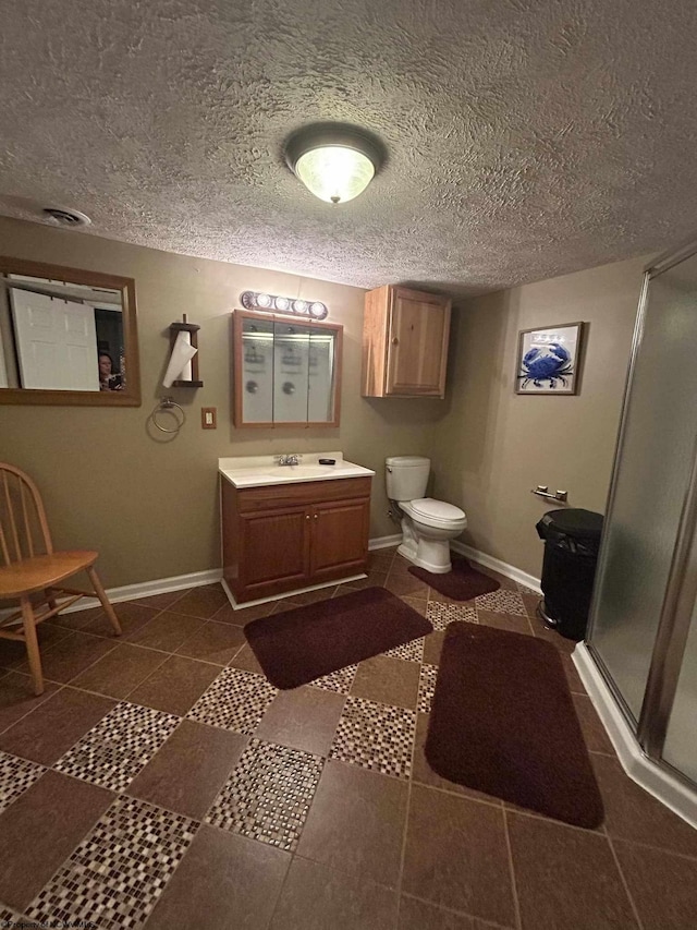 bathroom featuring toilet, a stall shower, tile patterned flooring, baseboards, and vanity