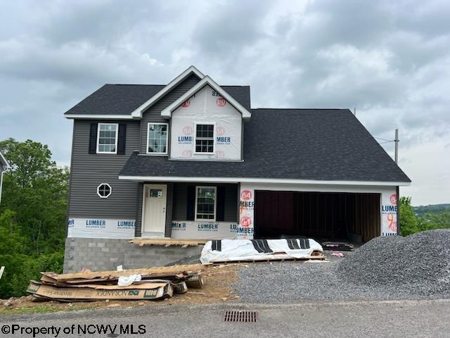 property under construction featuring a porch, driveway, and a garage