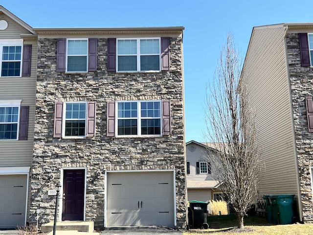 view of front facade with stone siding and a garage