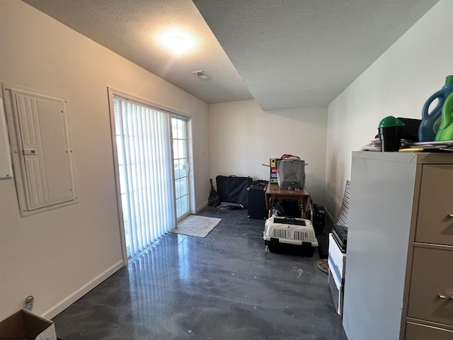 misc room featuring electric panel, baseboards, a textured ceiling, and concrete floors