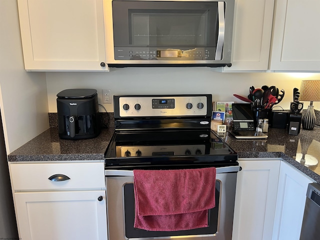 kitchen featuring dark countertops, white cabinets, and appliances with stainless steel finishes