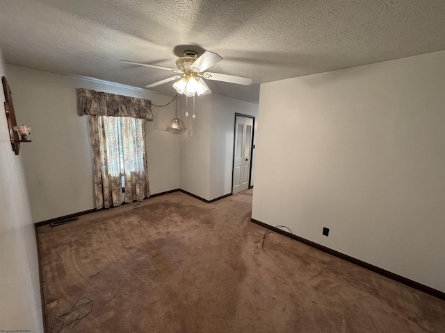 spare room with visible vents, light carpet, a ceiling fan, a textured ceiling, and baseboards