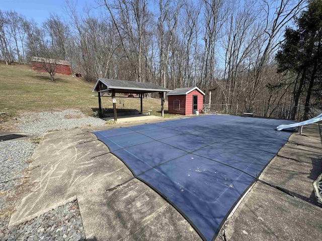 view of swimming pool with a yard and an outdoor structure