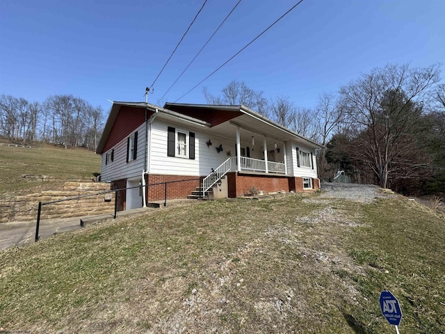 view of front of home featuring brick siding, covered porch, and an attached garage