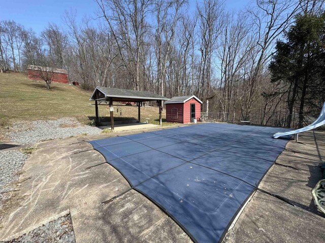 view of pool featuring an outdoor structure and a lawn