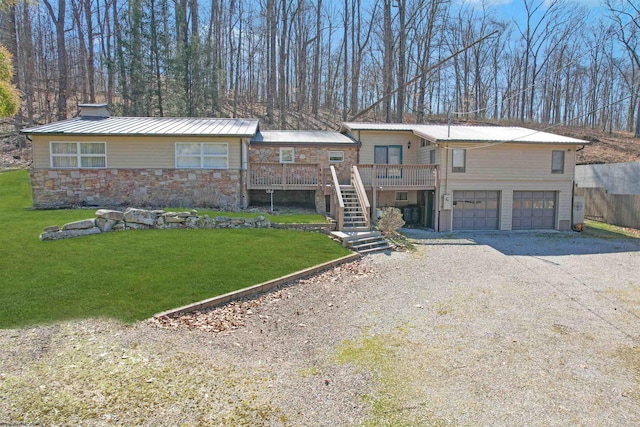 view of front of home featuring a front lawn, stairs, metal roof, stone siding, and driveway