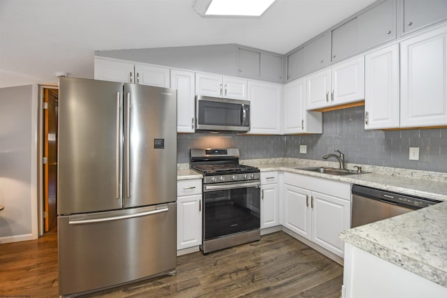 kitchen with a sink, stainless steel appliances, dark wood finished floors, and light countertops