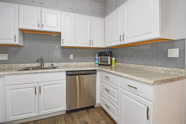 kitchen featuring white cabinetry, a sink, dark wood-type flooring, stainless steel dishwasher, and tasteful backsplash