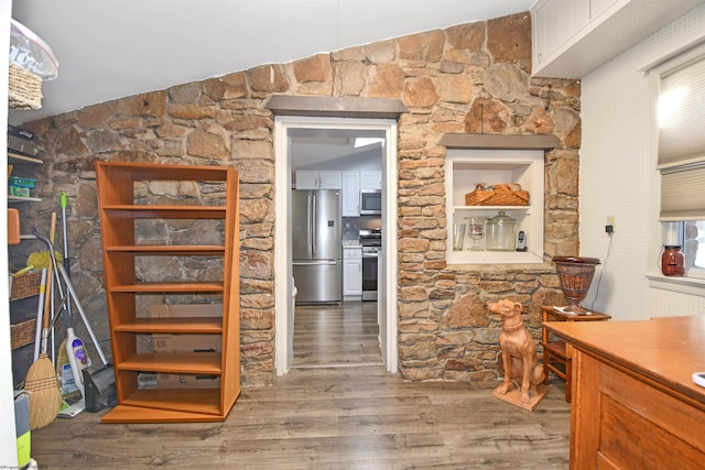 hall featuring lofted ceiling and wood finished floors