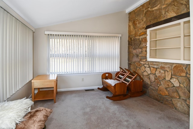 unfurnished room with built in shelves, baseboards, visible vents, carpet floors, and lofted ceiling