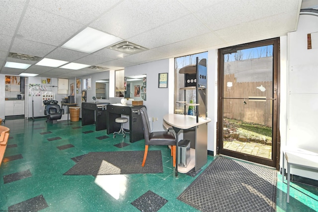 home office with tile patterned floors, visible vents, and a drop ceiling