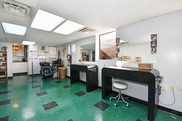 office featuring visible vents, a paneled ceiling, and dark floors