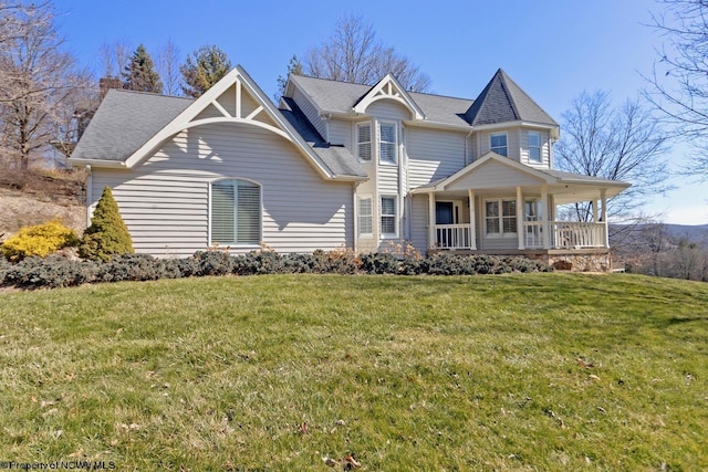 view of front of house with covered porch and a front lawn