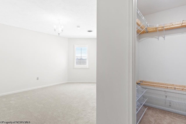 spacious closet with a notable chandelier, carpet flooring, and visible vents