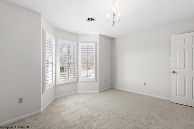 spare room with a notable chandelier, carpet flooring, baseboards, and visible vents