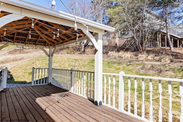 wooden terrace featuring a gazebo and a lawn