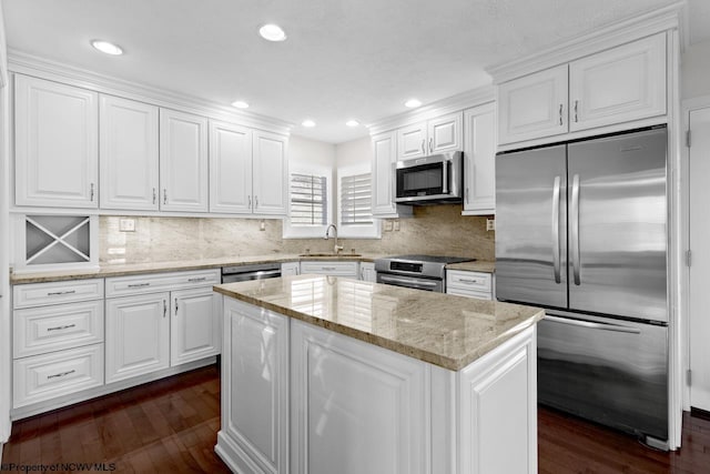 kitchen with dark wood-style flooring, white cabinets, stainless steel appliances, and a sink