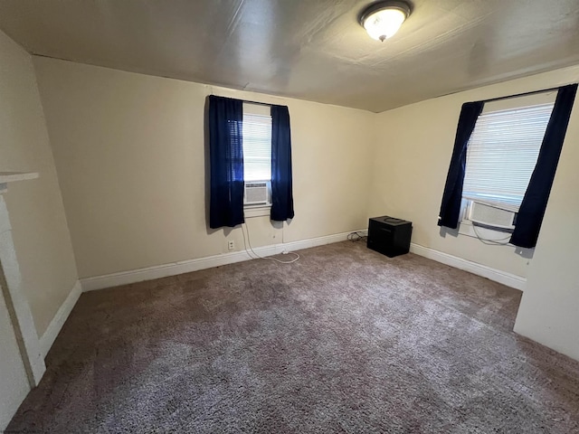 spare room featuring cooling unit, baseboards, and carpet flooring