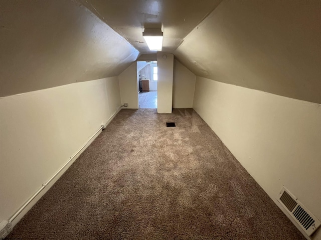 additional living space featuring visible vents, carpet flooring, and vaulted ceiling