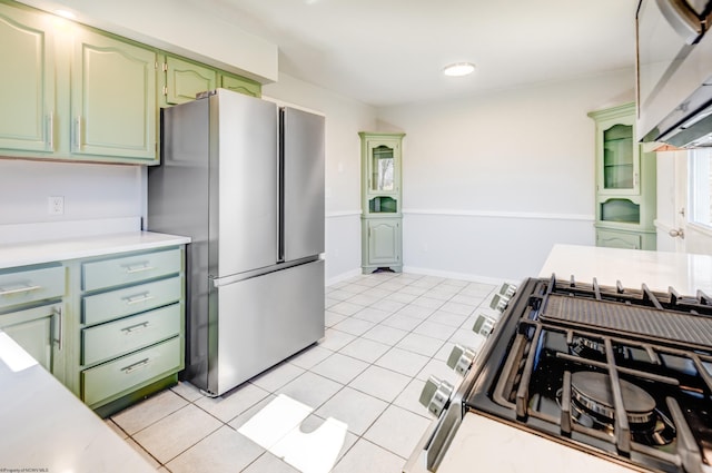 kitchen featuring green cabinets, light countertops, light tile patterned floors, and stainless steel appliances