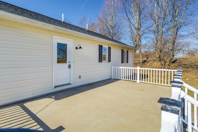 exterior space featuring a patio area and roof with shingles