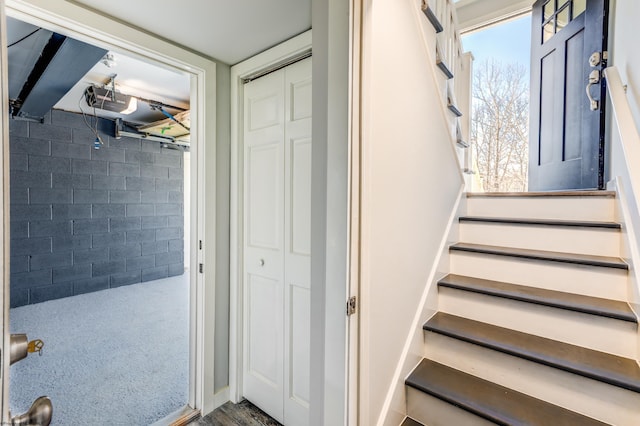 stairs featuring a wealth of natural light and concrete block wall