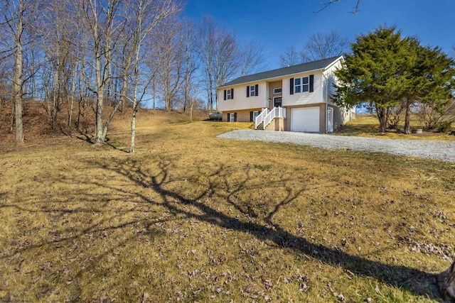 split foyer home with driveway, brick siding, and an attached garage