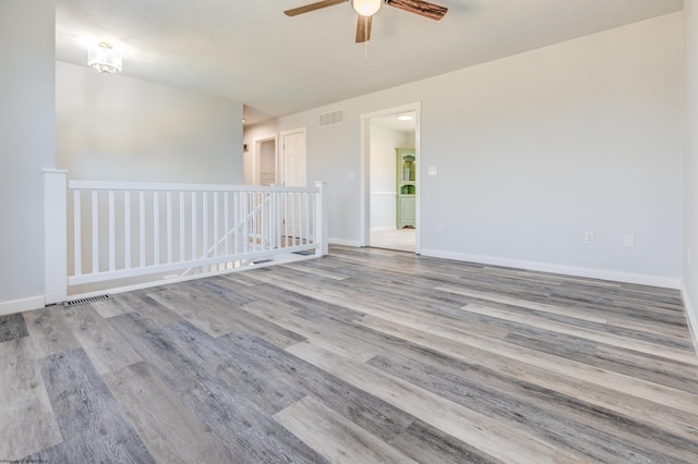 spare room with visible vents, baseboards, and wood finished floors