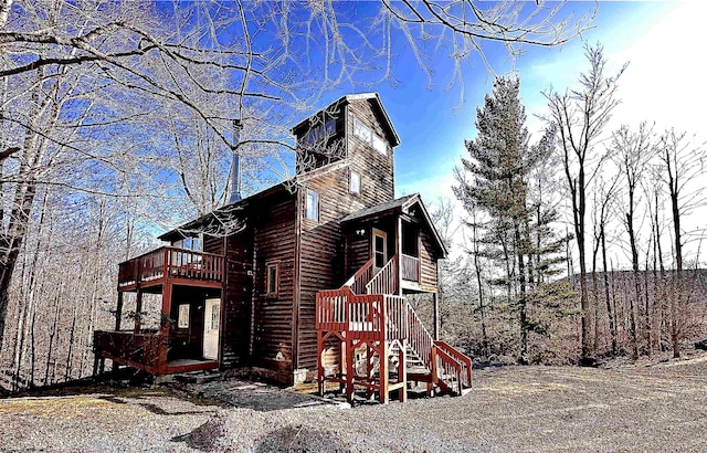 view of side of home featuring stairway and a wooden deck