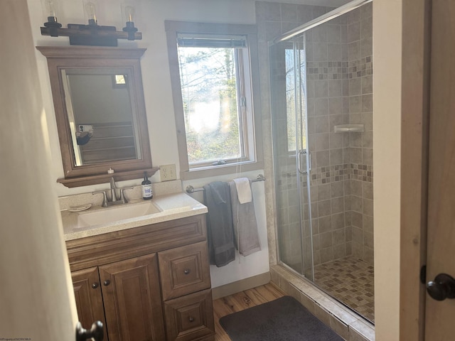 full bathroom with a shower stall, vanity, and wood finished floors