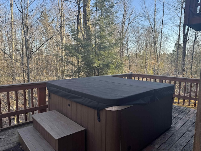 deck with a view of trees and a hot tub