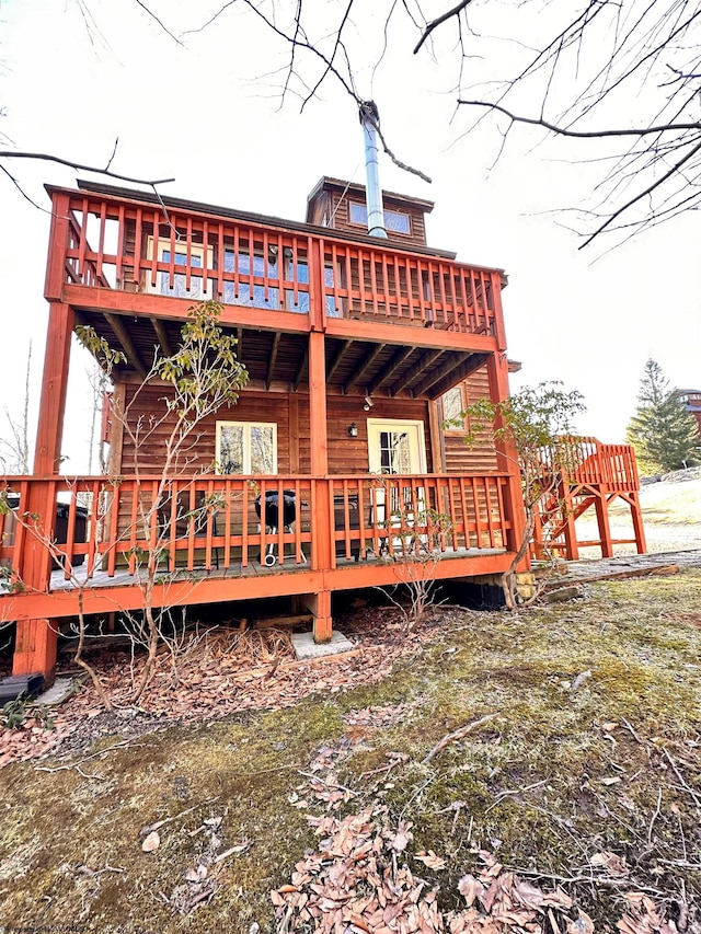 rear view of house featuring a wooden deck