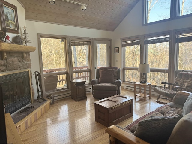 living room with light wood finished floors, a stone fireplace, wood ceiling, and high vaulted ceiling