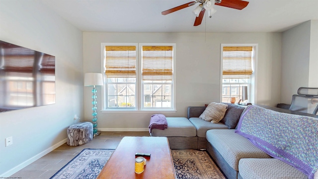 living area featuring baseboards, wood finished floors, and a ceiling fan