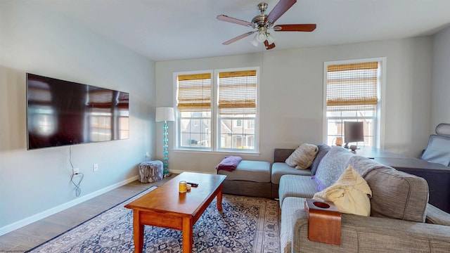 living room featuring ceiling fan, baseboards, and wood finished floors